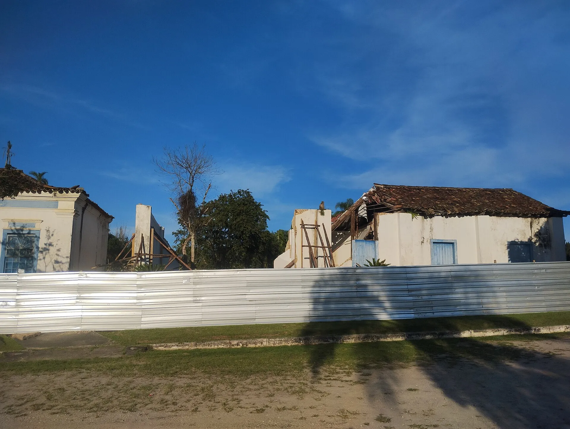 Construções antigas parcialmente arruinadas atrás de tapumes metálicos, no terreno do Museu Arqueológico de Araruama