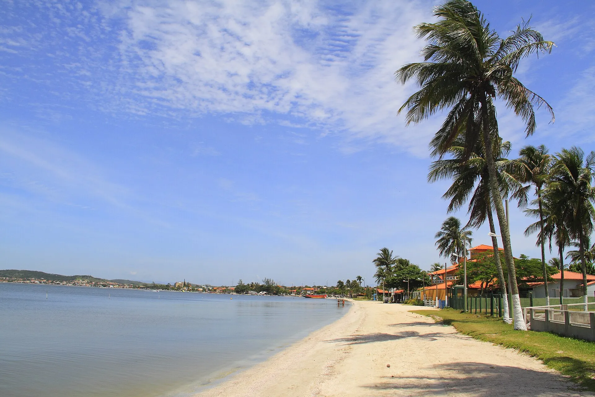 Faixa de areia clara com coqueiros à beira da Lagoa de Araruama, em Iguaba Grande