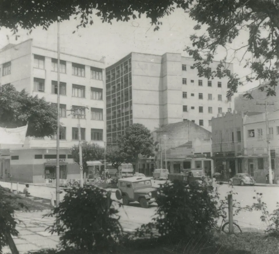 Fotografia em preto e branco do centro de Rio Bonito em 1970, com prédios de vários andares atrás de uma praça arborizada